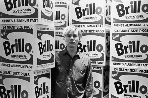 American pop artist Andy Warhol (1928 - 1987) stands amid his towering Brillo box sculptures in the Stable Gallery (33 East 74th Street), New York, New York, April 21, 1964. (Photo by Fred W. McDarrah/Getty Images)